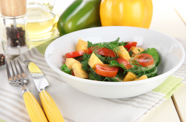 Light salad in plate on wooden table