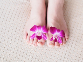 Young woman's feet and orchid flower