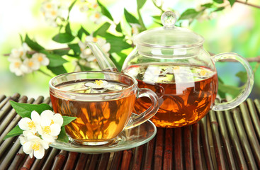 Cup of tea with jasmine, on bamboo mat, close-up