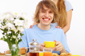 Young happy man drinking tea