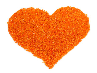 Heart of orange crystals of sea salt on grey background