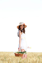 Obraz premium Portrait of beautiful young woman with flowers in the field