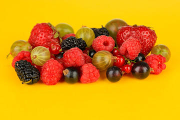 Ripe berries on yellow background