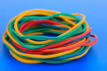 Colorful rubber bands on blue background