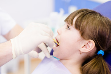 Obraz na płótnie Canvas dental examining being given to little girl by dentist