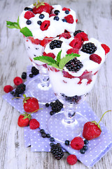 Natural yogurt with fresh berries on wooden background