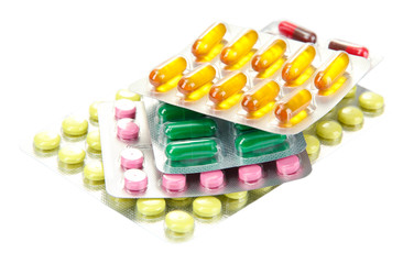 Capsules and pills packed in blisters, isolated on white