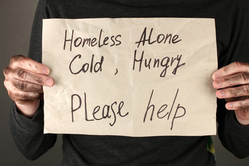 homeless man asks for help, on black background close-up