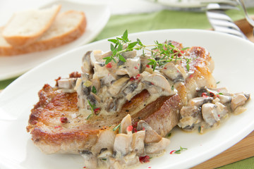 Pork steak with mushroom sauce and cream.