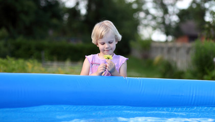 Dziewczynka z kwiatkiem nad basenem kąpielowym.