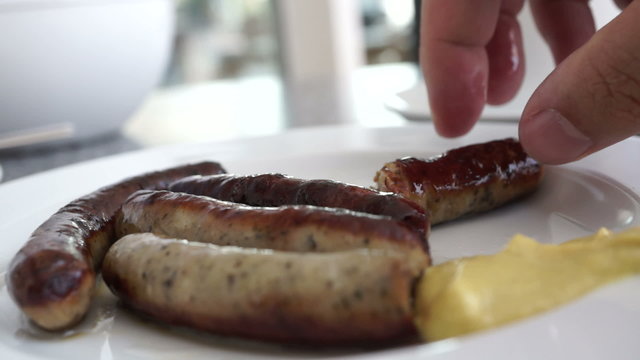 Eating sausage with mustard