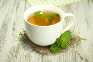 \cup of herbal tea with fresh mint on wooden table