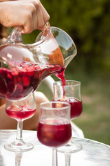 Hand serving sangria in a glass