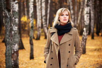 Blond woman walking in autumn forest