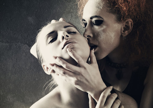 Vampire's kiss. Fantasy female portrait against dark grungy back
