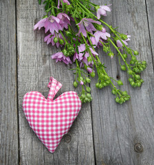 Rustic still life with a bouquet of mallow and heart on a wooden