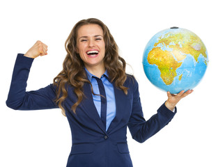 Happy business woman showing earth globe and biceps