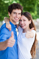 Young couple with thumbs up