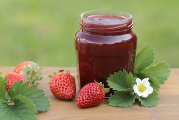Glass with strawberry jam and strawberries