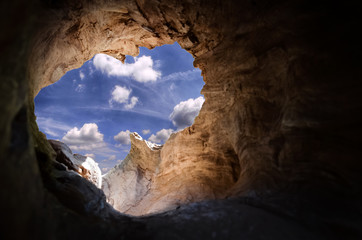 Cave to the outside with view on sky with clouds