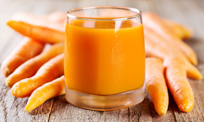 glass of carrot juice with fresh carrots