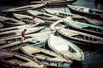 Old boats on brown waters of Ganges river, Varanasi, India