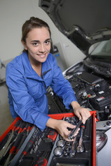 Fototapeta na wymiar Student girl in mechanics working on car engine