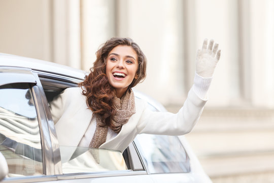 Hello! Beautiful Young Woman Looking Out From A Car Saying Hello