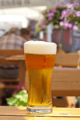 Glass of beer in restaurant on the table outdoor in the sun