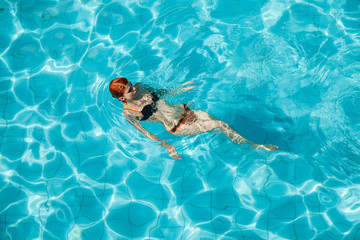 Young redhead woman in swimming pool
