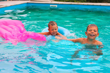 Fototapeta premium Two brothers are swimming in the pool