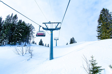 Obraz premium Ski lift with chairs. Lift to the top of the mountain at ski re