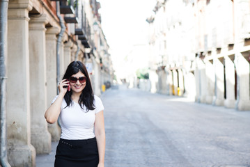 Obraz premium Smiling girl talking and walking in the street