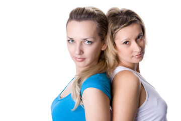 Portrait of two pretty young women, standing back to back