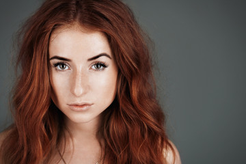 Fototapeta premium red-haired girl with freckles in the studio. Teen girl with brig