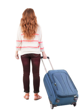 back view of walking  woman  with suitcase.