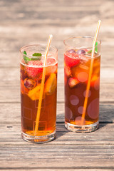 Iced tea with  lemon and mint on wooden table, outdo