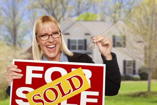 Woman with Sold Sign and Keys in Front of House