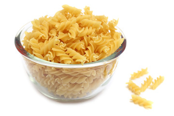 Fusilli pasta in a glass bowl on white background