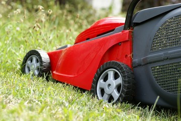 Detail of red cutting machine on grass.