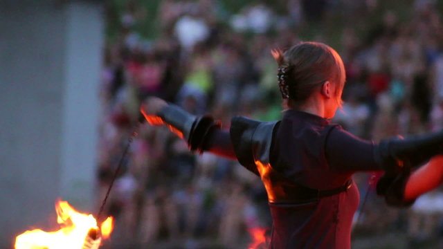 Flame artist perform using burning chain fire pois and sticks