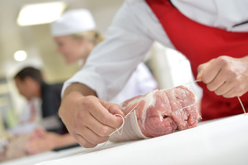 Obraz na płótnie Canvas Zbliżenie z pieczonego mięsa przygotowywanym przez rze¼nika