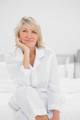 Cheerful  woman sitting in her bedroom