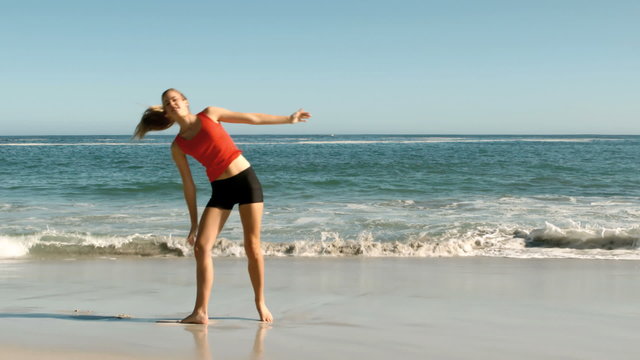 Attractive woman doing cartwheels on the beach
