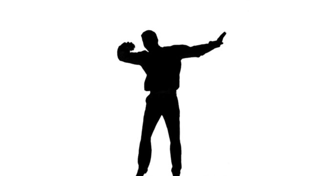 Silhouette of a man jumping and raising legs on white background