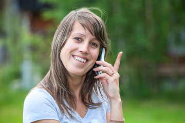 Young pretty woman smiling then calling on mobile phone