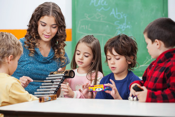 Teacher Teaching Students To Play Xylophone In Class