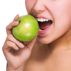 Beautiful young woman eating an apple. Isolated over white