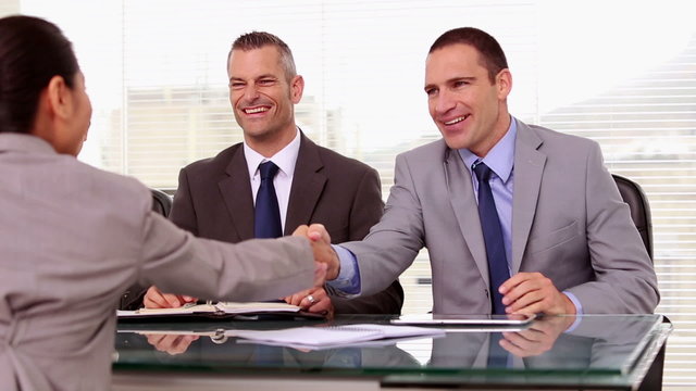 Job applicant shaking hands of business people during a job