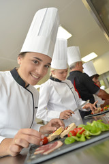 Team of young chefs preparing delicatessen dishes